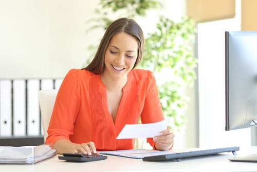 A woman smiles as she goes through her taxes