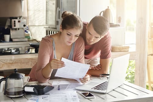 Two people hover over their taxes