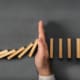 Chain Reaction In Business Concept, Businessman Intervening Dominoes Toppling