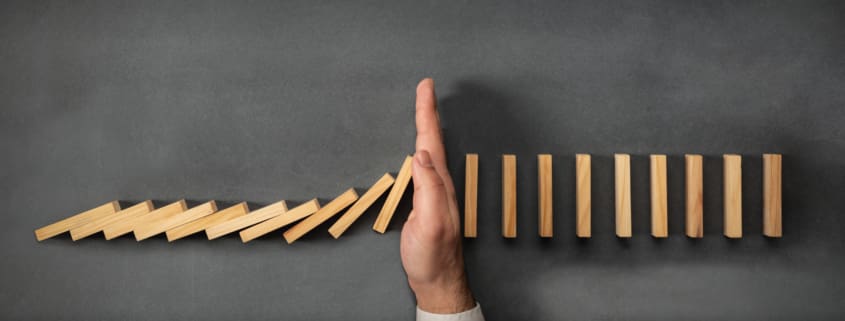 Chain Reaction In Business Concept, Businessman Intervening Dominoes Toppling