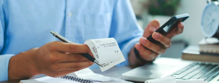 Man using smartphone and holding bills