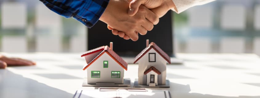 Real estate agents shake hands after the signing of the contract agreement is complete.