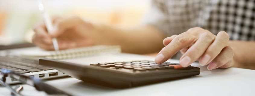 Man holding a pen and a calculator