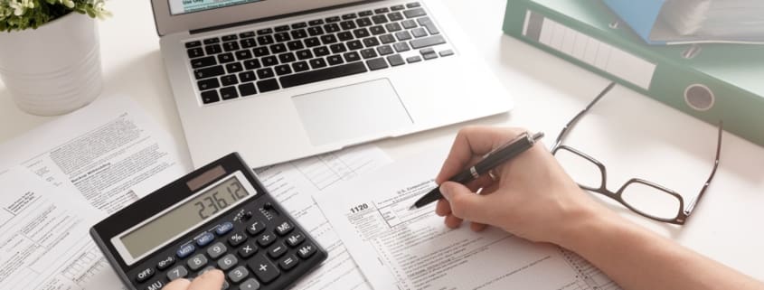 Man using a pen and a calculator