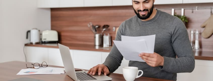 Man smiling while holding a paper