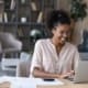 Woman smiling while using a laptop