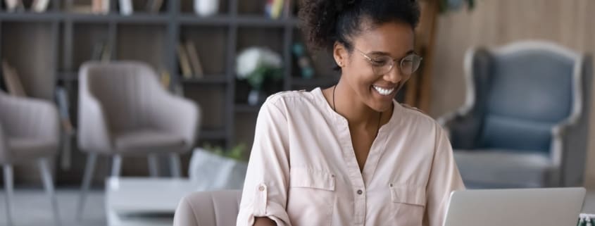 Woman smiling while using a laptop