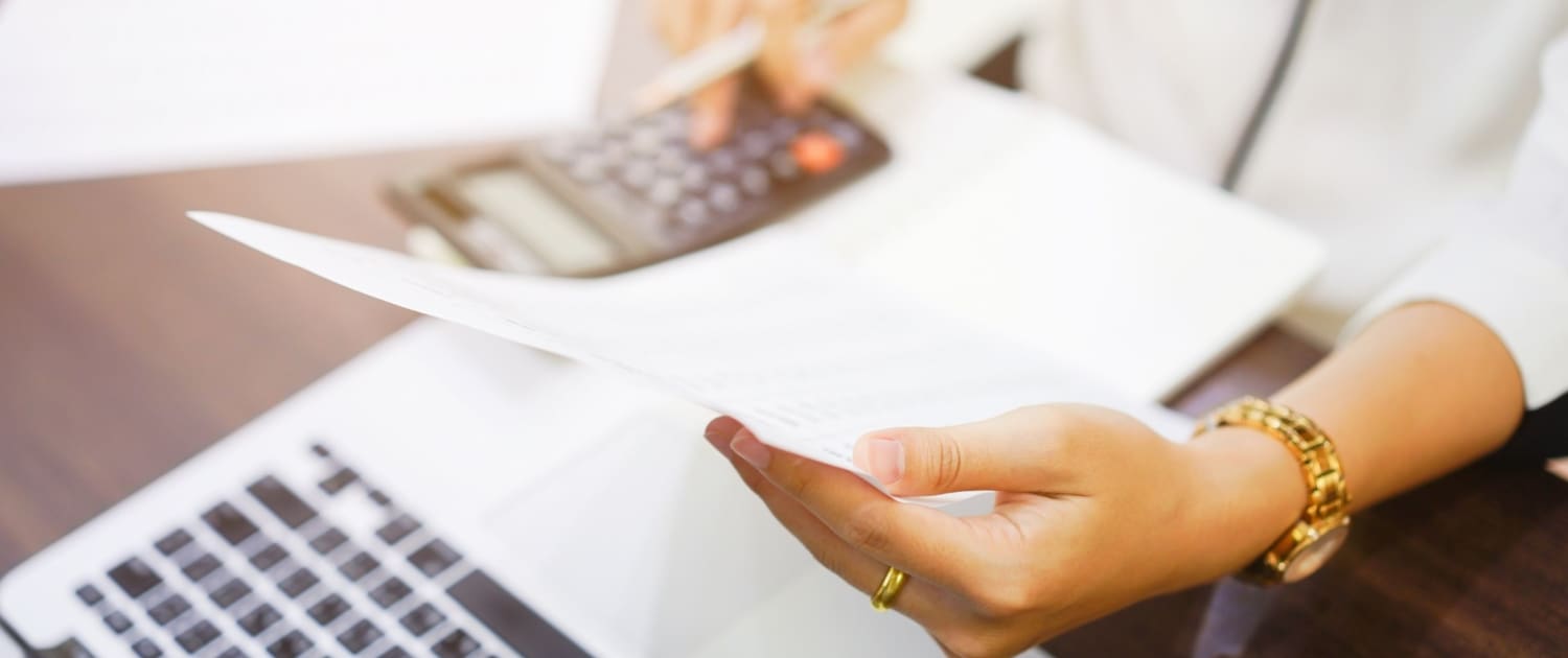 Woman holding a paper and a calculator