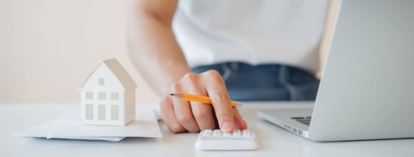 Man holding a pencil and calculator